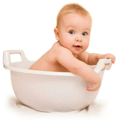 Baby sitting in a white bathtub with raised side handles against a white background.