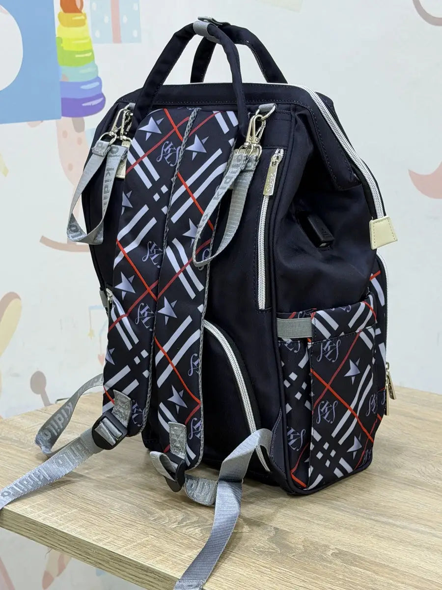 Kidilo Plaid-Print: black rear view on wooden table with plaid straps and grey loops.