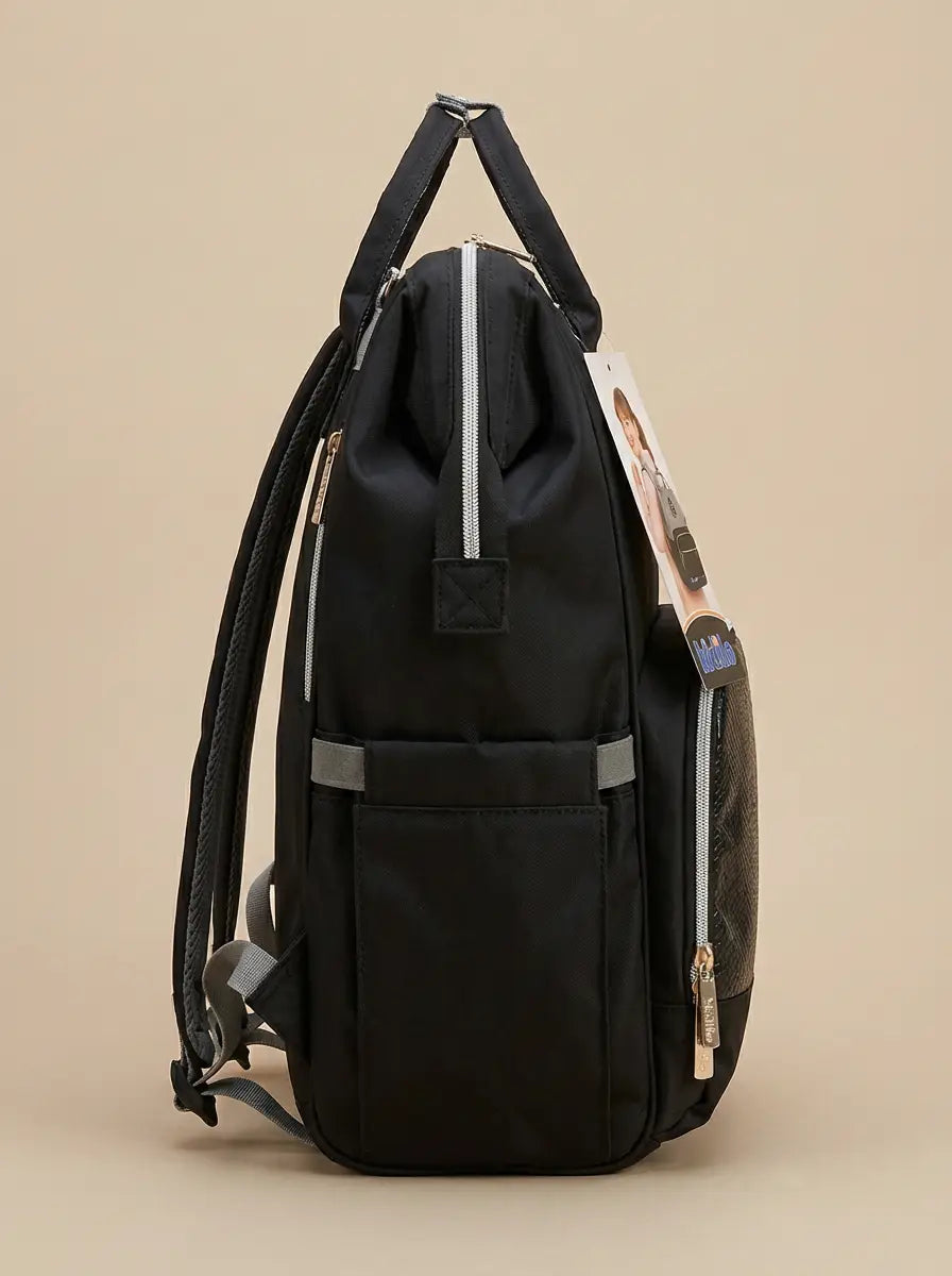 Kidilo black diaper backpack side view with tall side pocket, grey trim, top handles and hanging product tag.