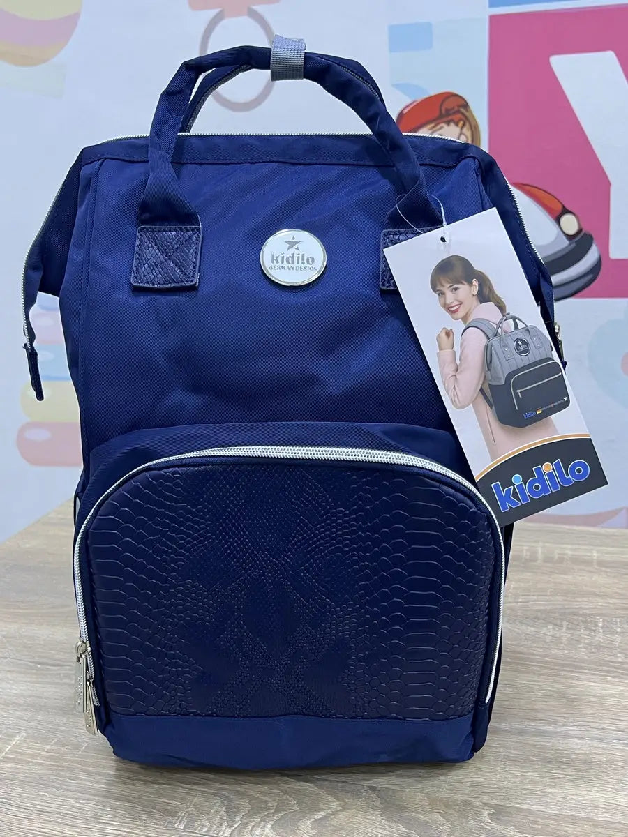 Kidilo blue diaper backpack photographed from the front, with patterned pocket, silver-coloured zip and product tag.