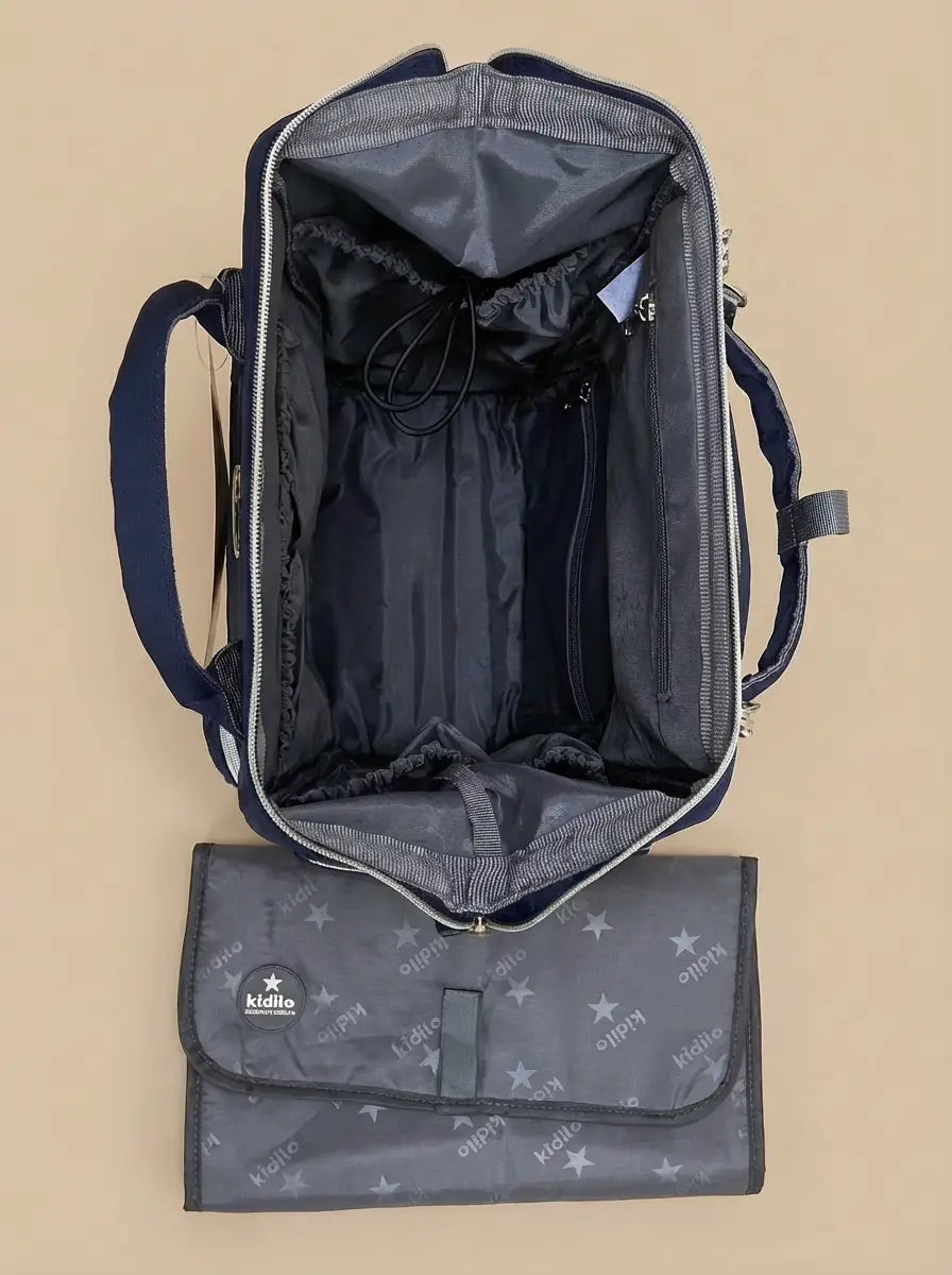 Kidilo blue diaper backpack open from above on a beige background, with grey interior and matching changing mat.