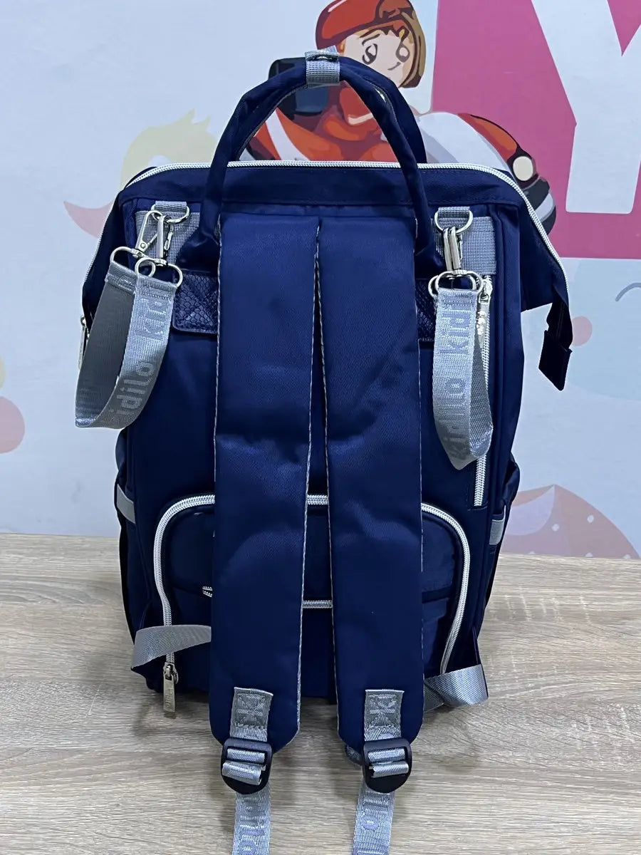 Kidilo blue diaper backpack rear view with grey hanging loops, padded straps and adjustable lower buckles.