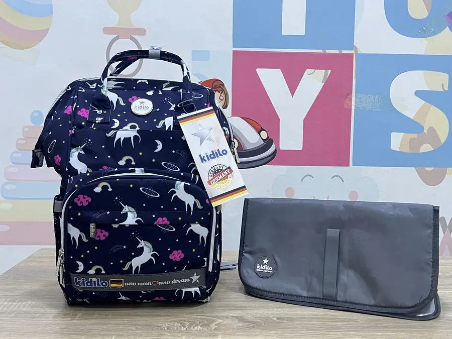 Kidilo Unicorn-Print: navy front view beside grey changing mat on wooden surface.