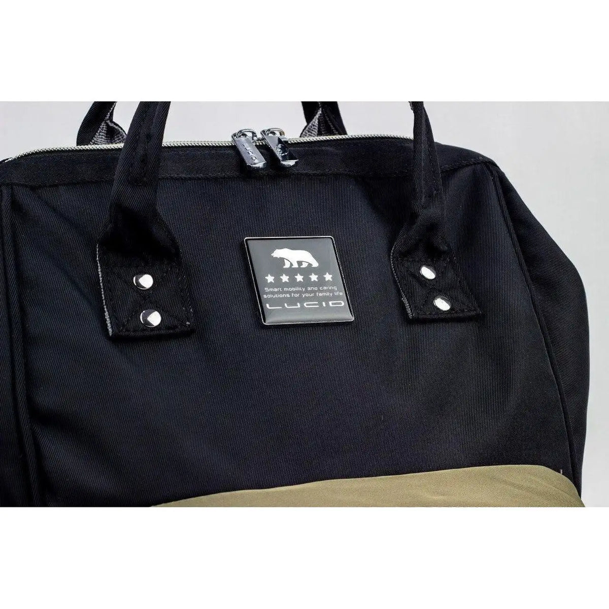 Lucid diaper backpack – close-up of black upper panel, paired handles and Lucid brand label