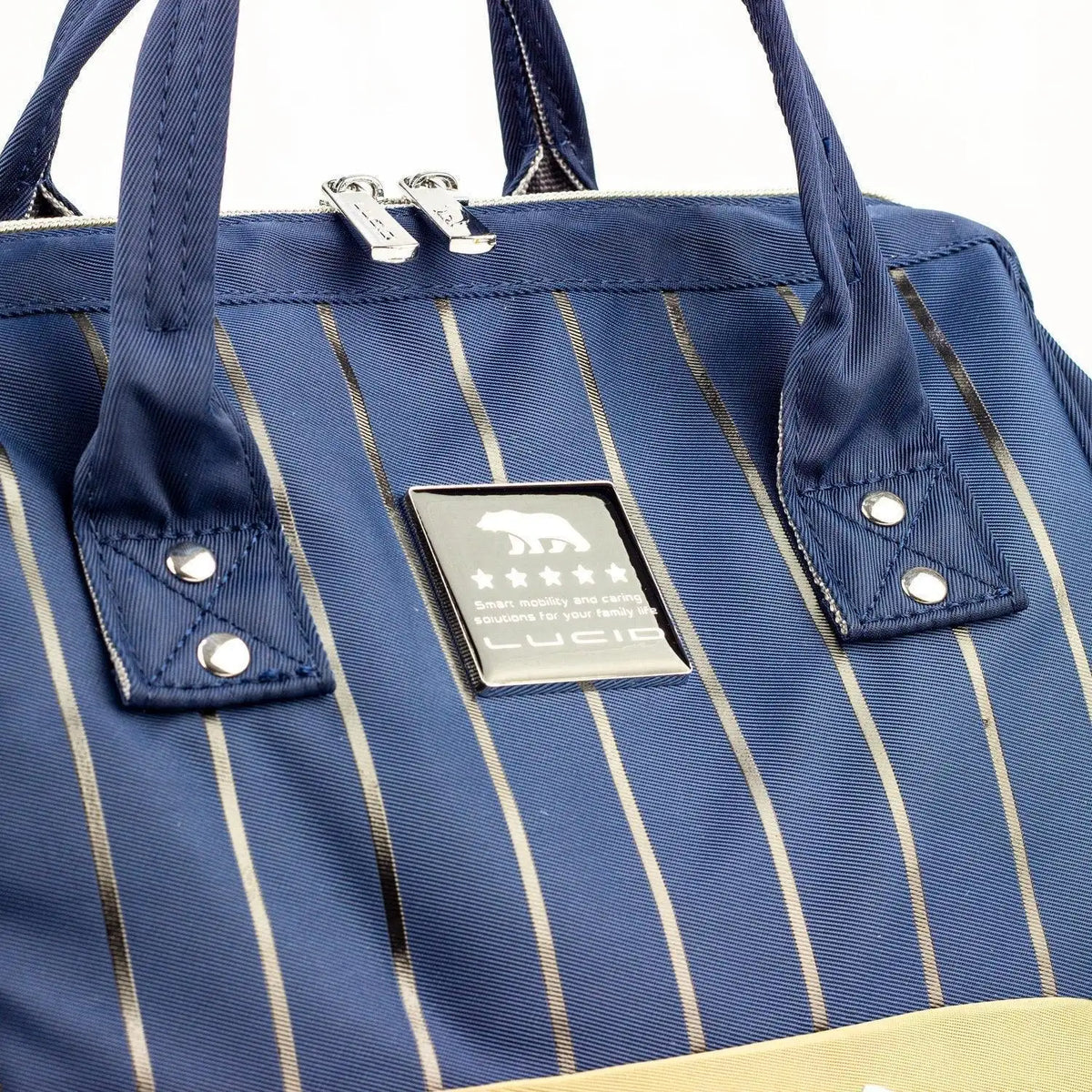 Lucid diaper backpack – close-up of navy pinstriped upper panel, handles and brand label