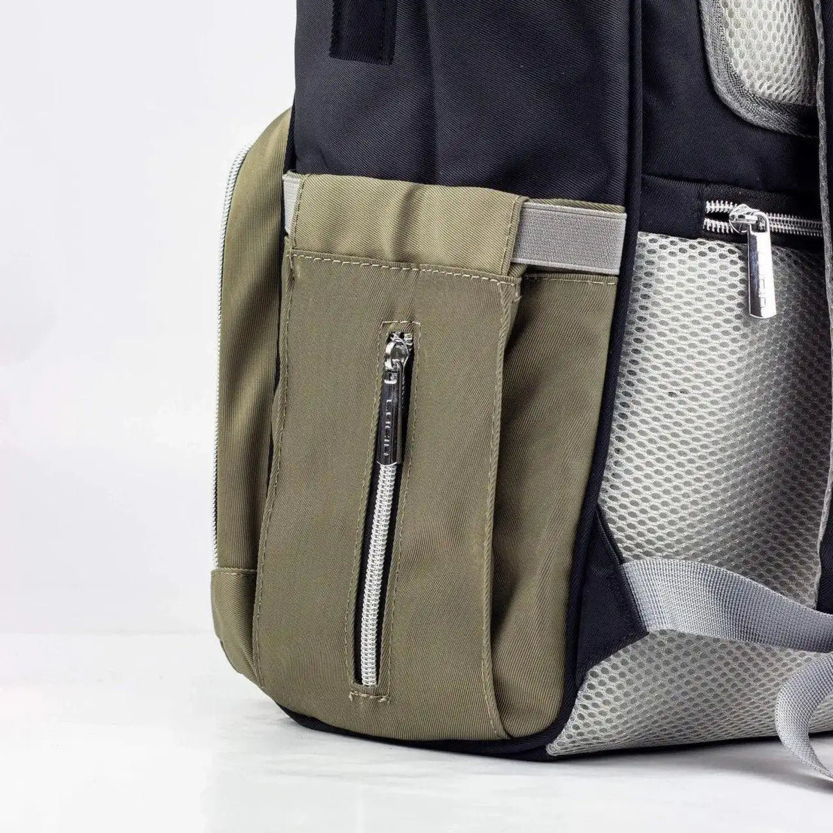 Lucid diaper backpack – close-up of olive side pocket and padded grey back panel