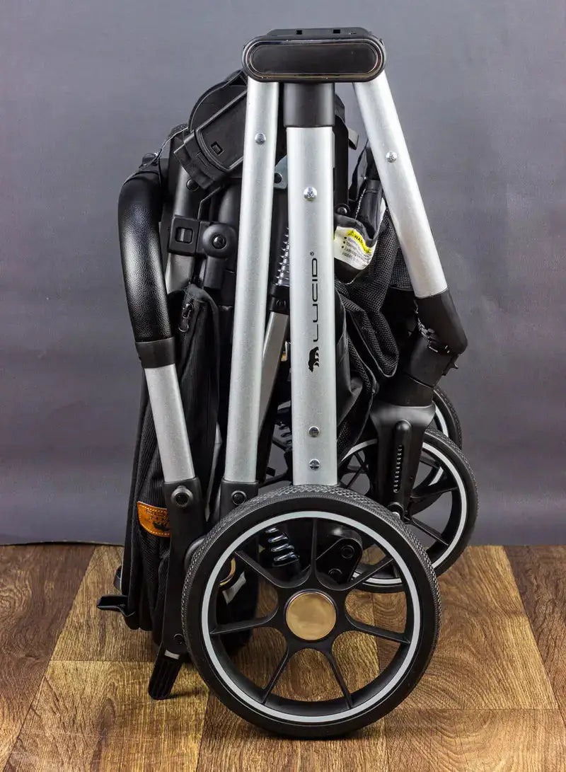 Lucid VIOLA LC8: Folded black stroller showing frame and rear wheel from the side