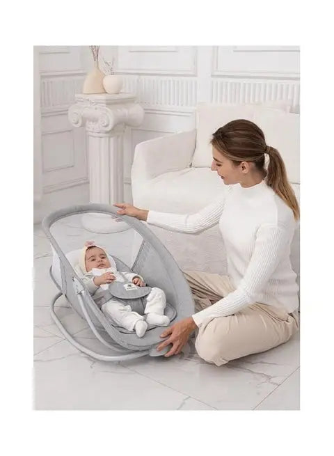 Mastela 4-in-1: mother seated beside child in grey swing with raised mesh net.