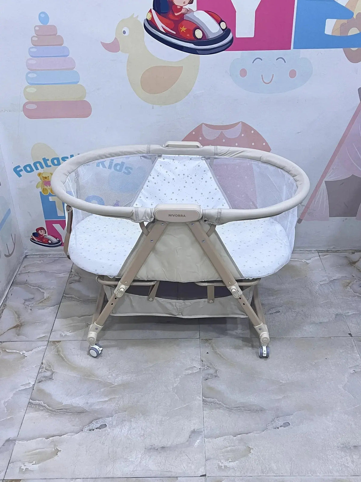 Nivorra NB-3F: beige bassinet side view on tiled floor without the mosquito net.