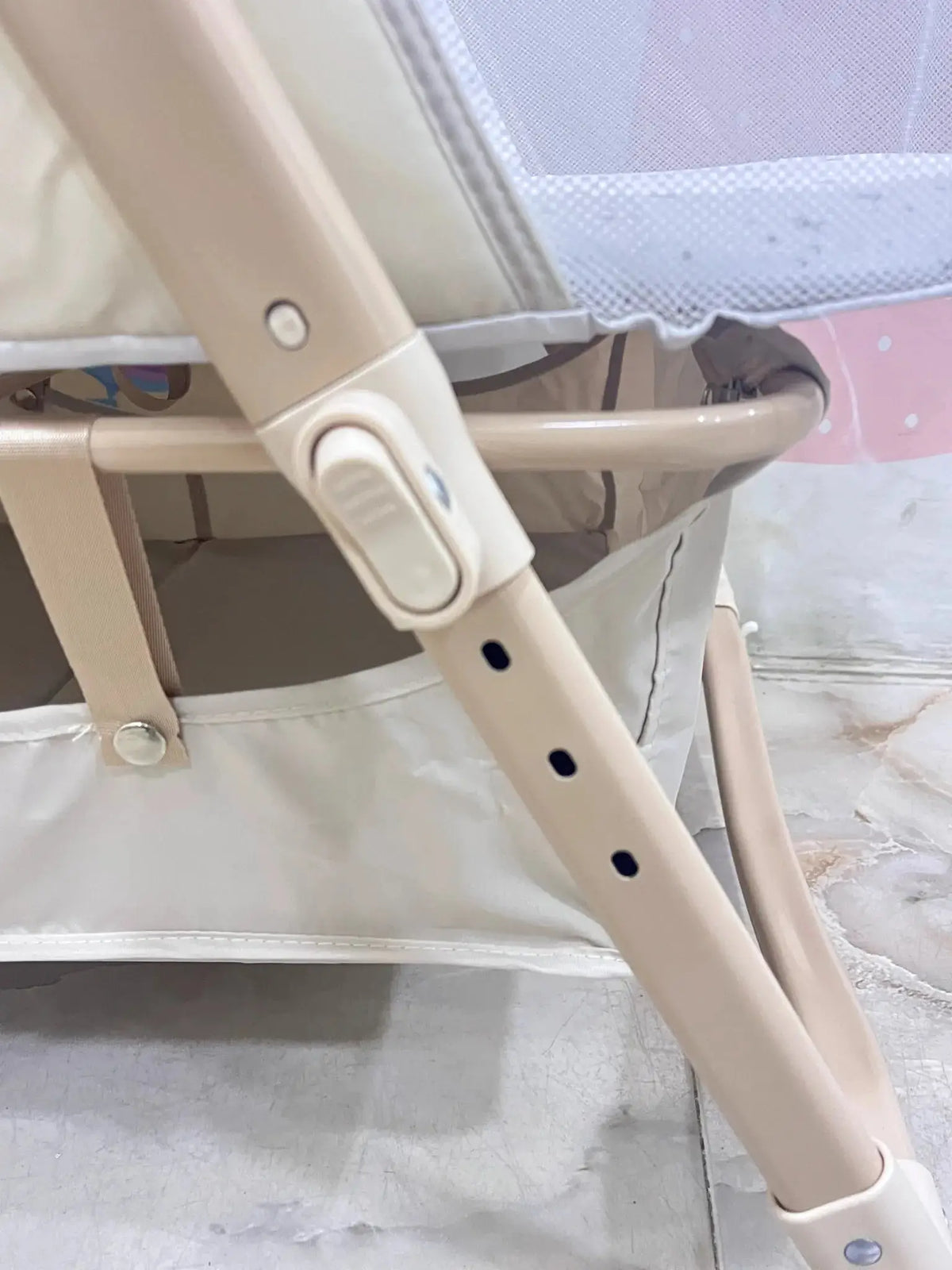 Nivorra NB-3F: close-up of beige height-adjustment button and frame holes.