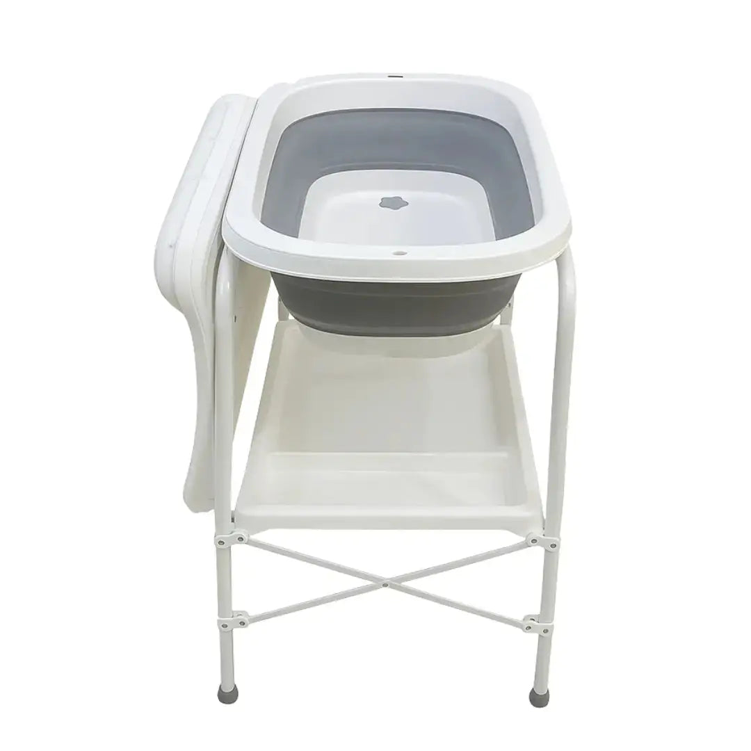 QC6606: Grey baby bath on white stand with changing surface at the side and lower shelf.