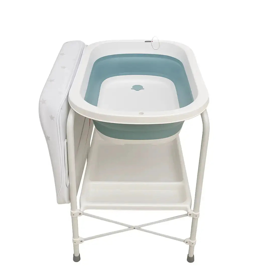 QC6606: Mint green baby bath on white stand with side changing surface and lower shelf.