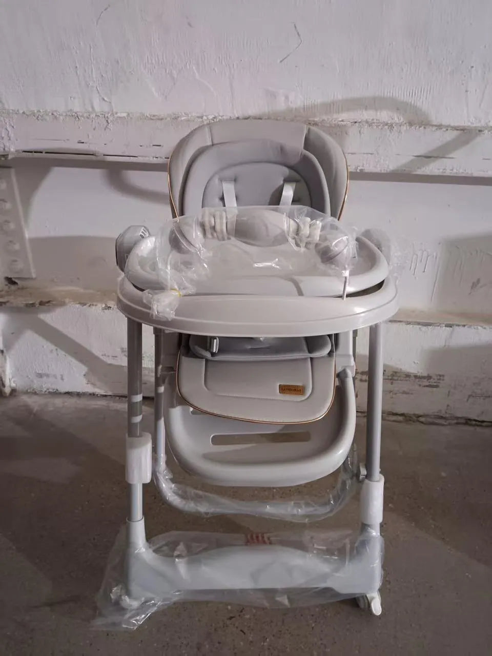 Umbrella X17 Pro: beige high chair front view with padded seat, tray and footrest.