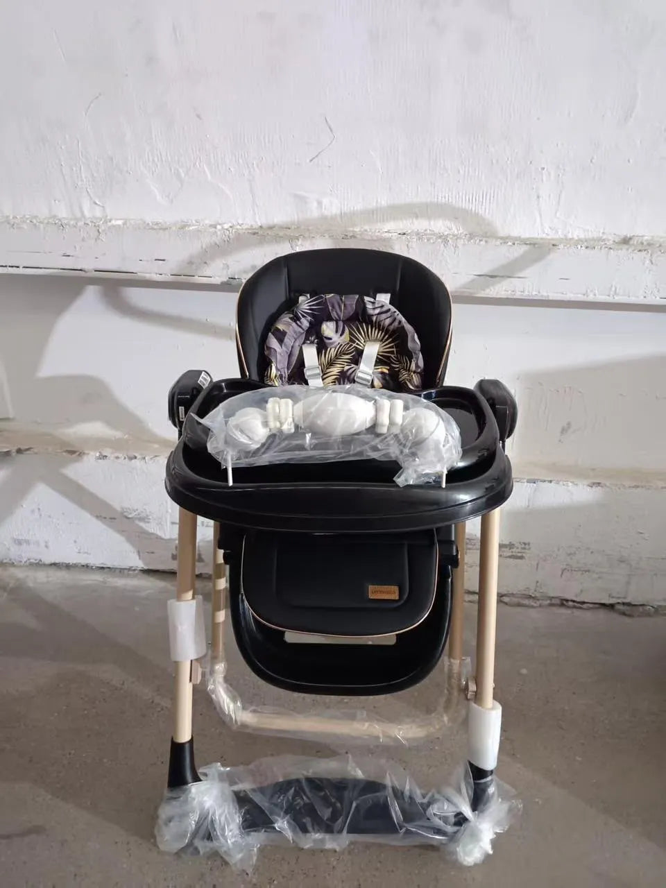 Umbrella X17 Pro: black high chair front view with wrapped tray and padded footrest.