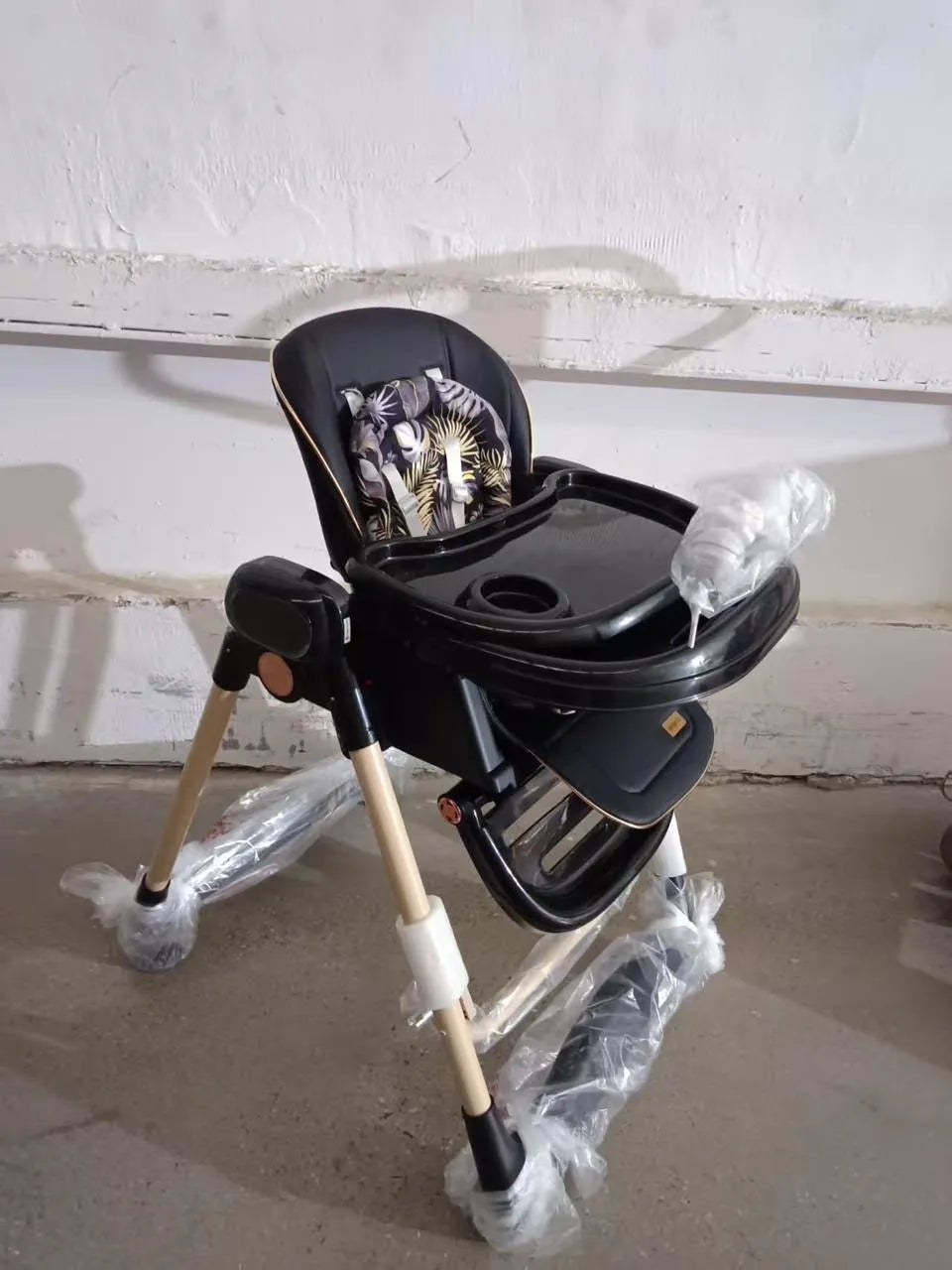 Umbrella X17 Pro: black high chair side angle with tray and protective wrapping on legs.