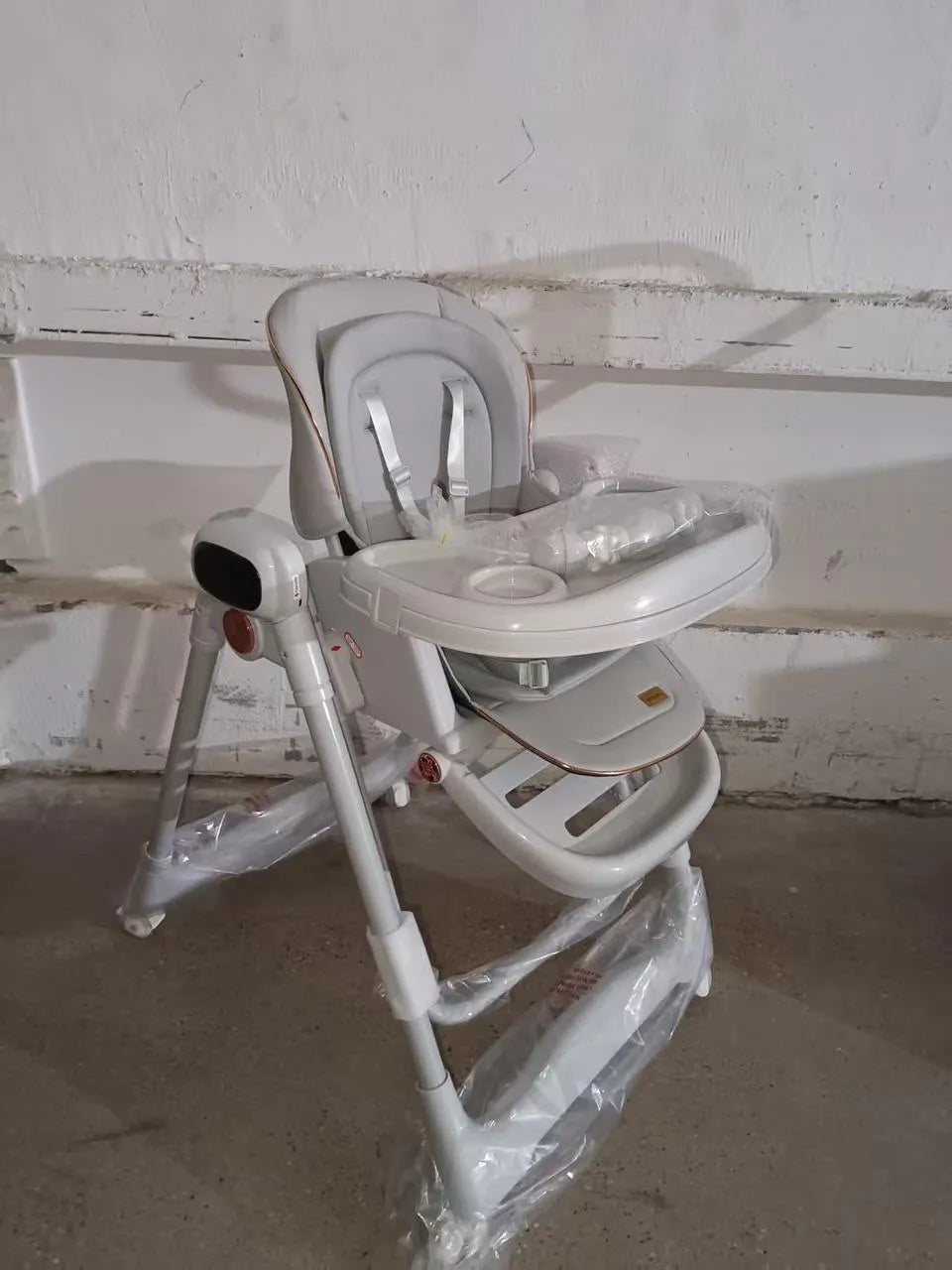Umbrella X17 Pro: light grey high chair three-quarter view with white harness and wrapped tray.